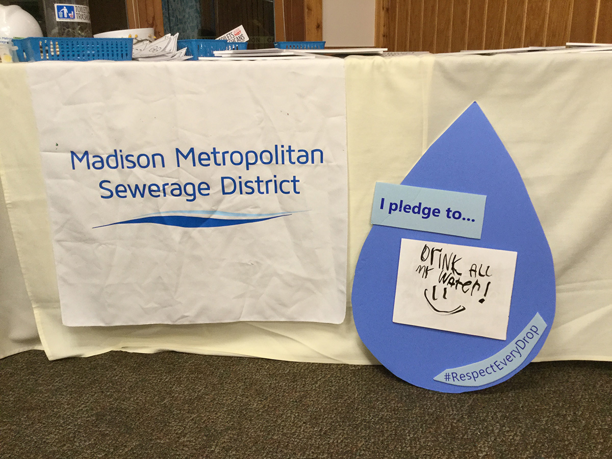 Visitor table at Madison Metropolitan Sewerage District with sign that says "I pledge to drink all my water".