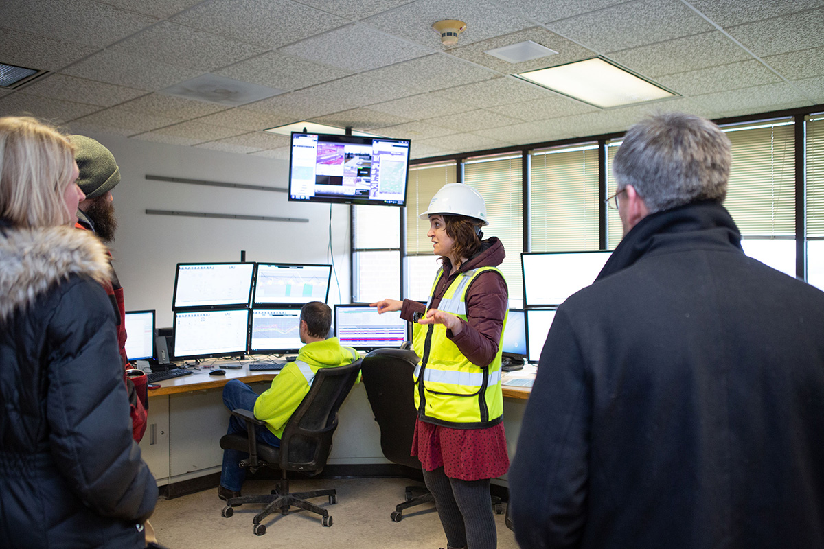 A District staff member showing a tour group the operator room.